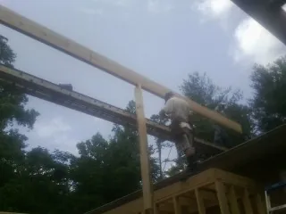 Carpenter setting a ridge beam over a new addition frame — Ice Dam Removal by Roofing Brothers in Hattiesburg