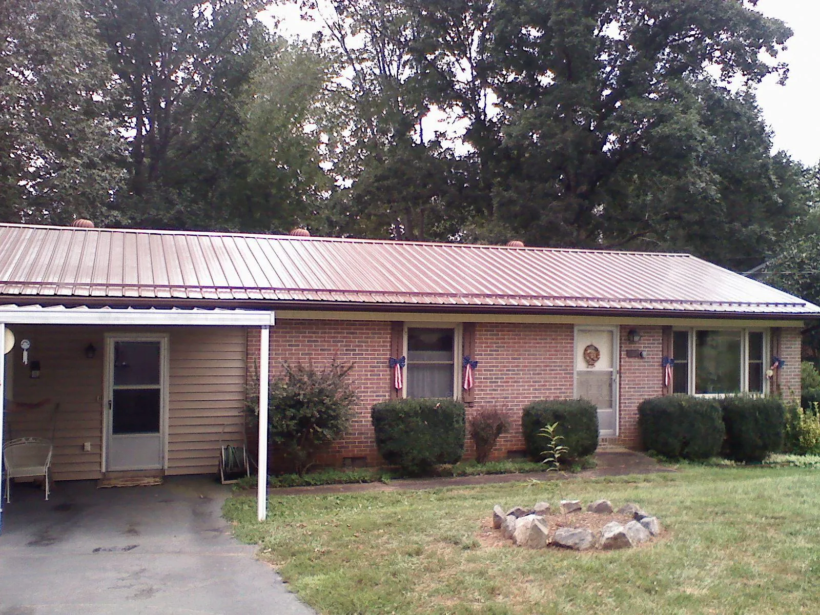 Bronze metal roof and carport on a brick ranch home — Roof Repair work by our crew in Hattiesburg