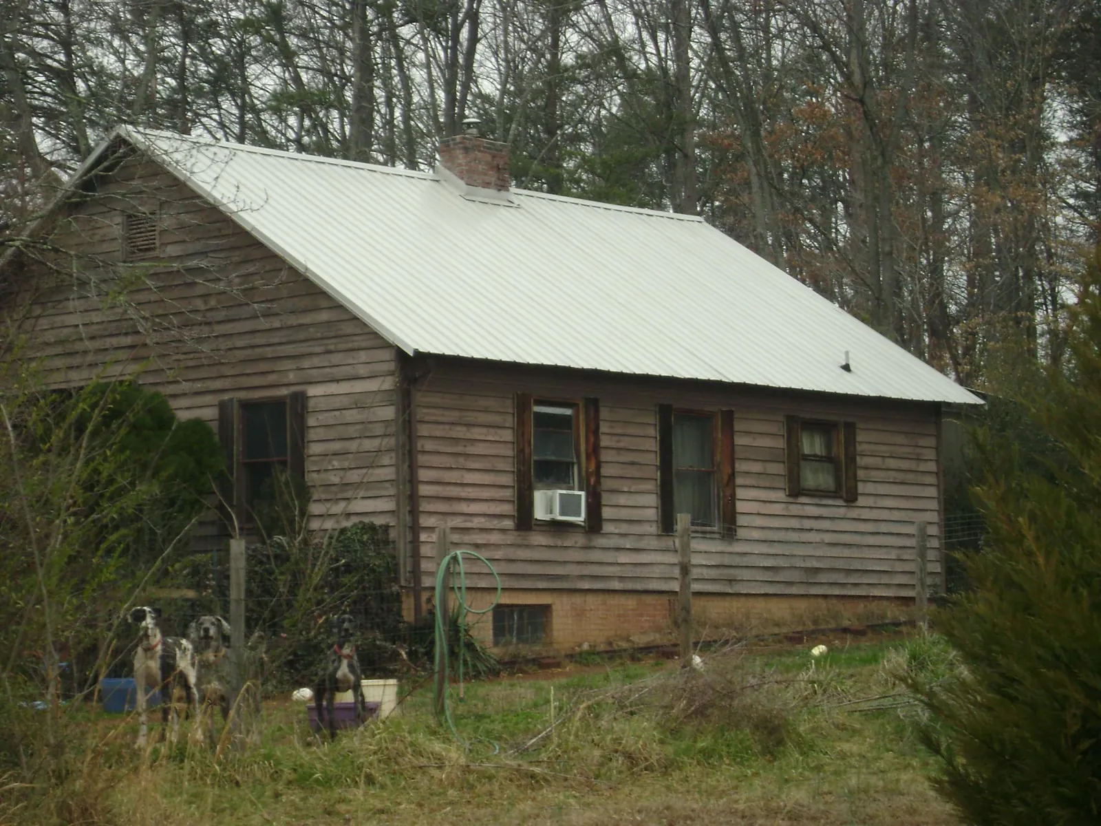 White metal roof on an old wood sided farmhouse, from a Metal Roof Installation job in Hattiesburg